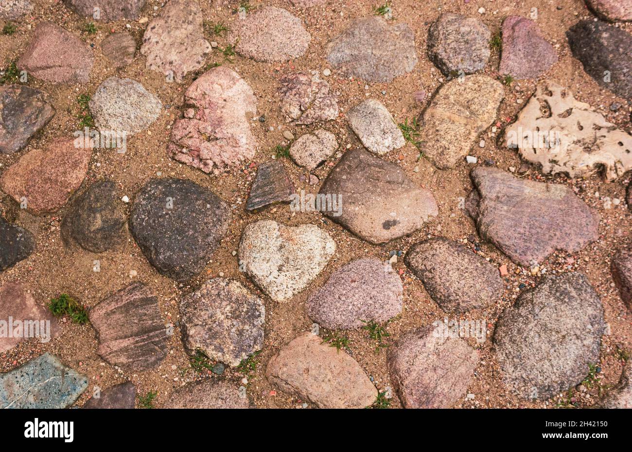 Steinpflaster mit runden Steinen. Altes Bürgersteig in Europa Stockfoto