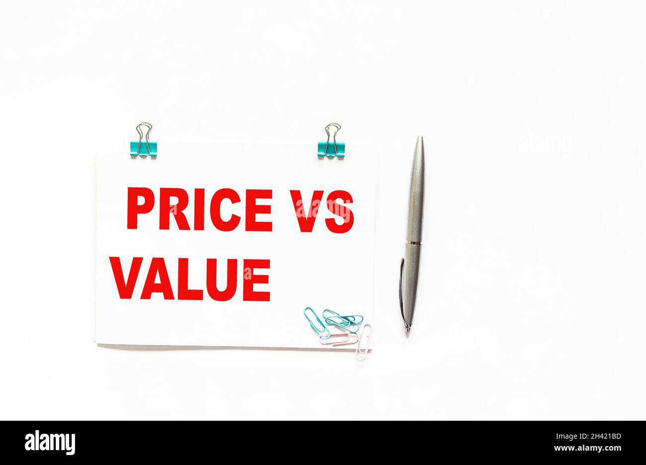 Notizblock mit den Worten Preis versus Wert , auf weißem Hintergrund mit einem Stift. Ort zum Schreiben Stockfoto