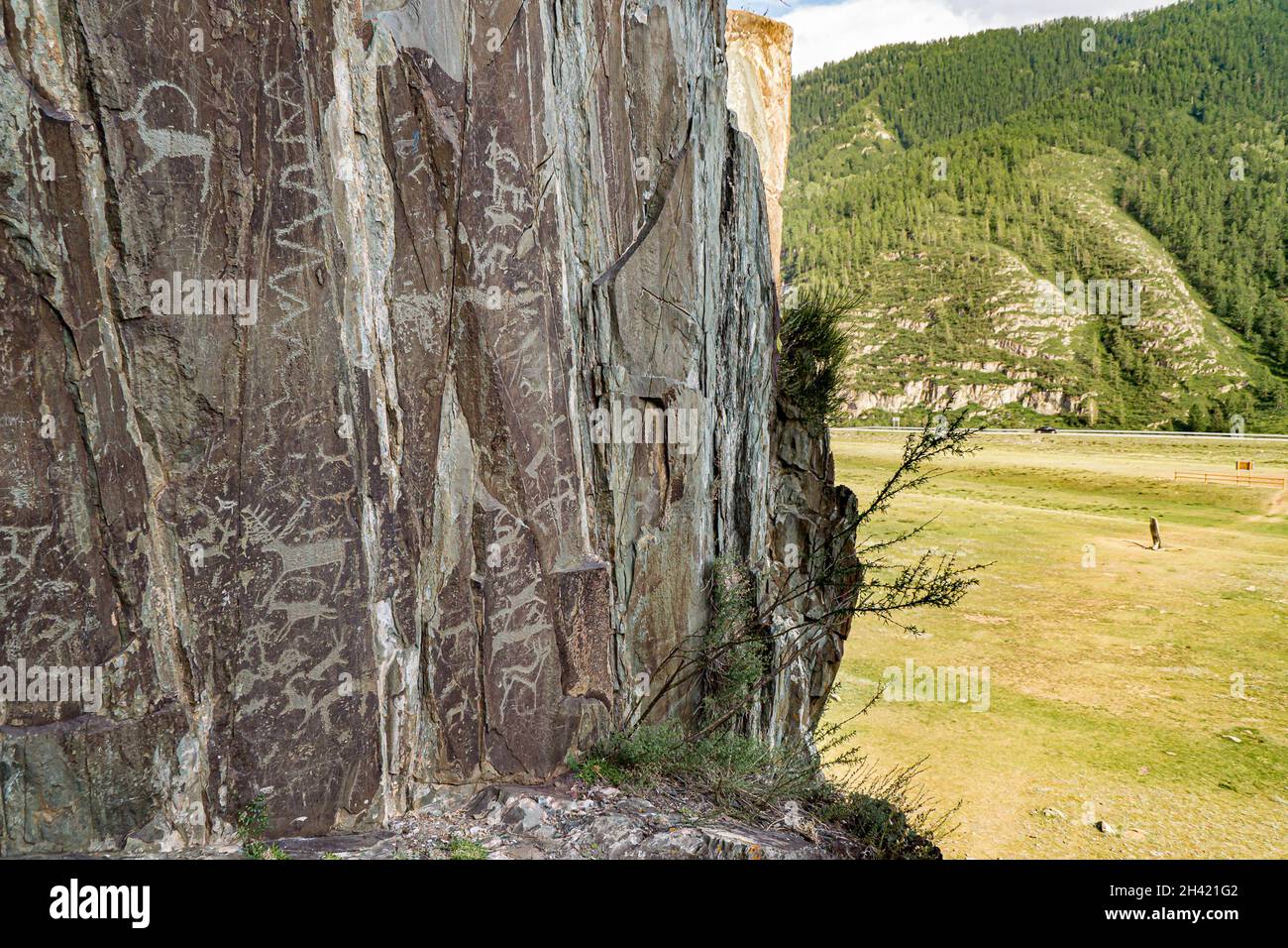 Felsschnitzereien alter Menschen in Kalbak-Tasch, in der Ferne befindet sich der Chuisky-Hirsch-Stein Adyr-Kan oder Chuisky-Olenny Stockfoto