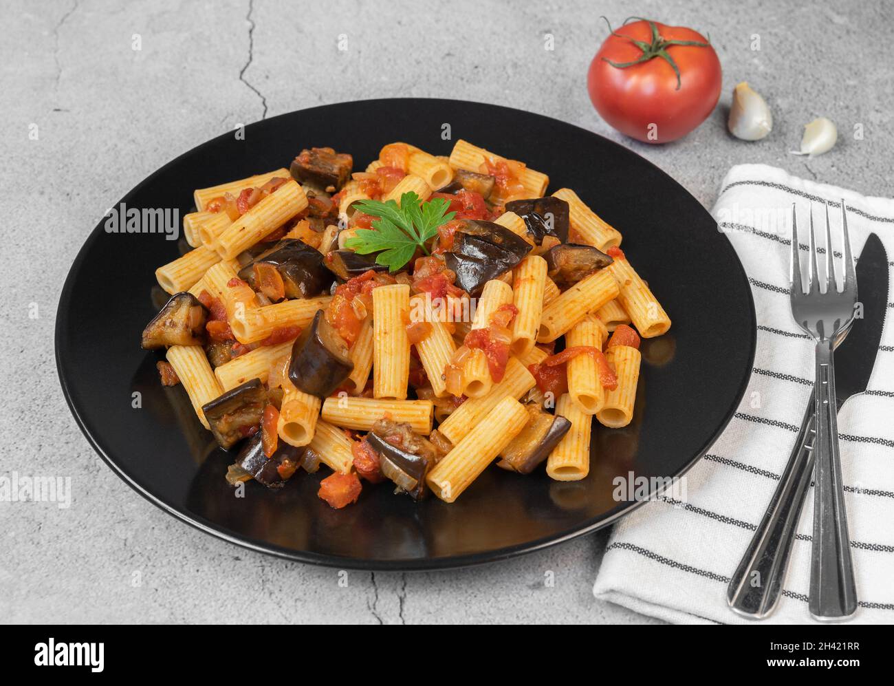 Rigatoni Pasta mit Auberginen, Tomaten in einer schwarzen Schüssel. Italienisches Essen. Stockfoto