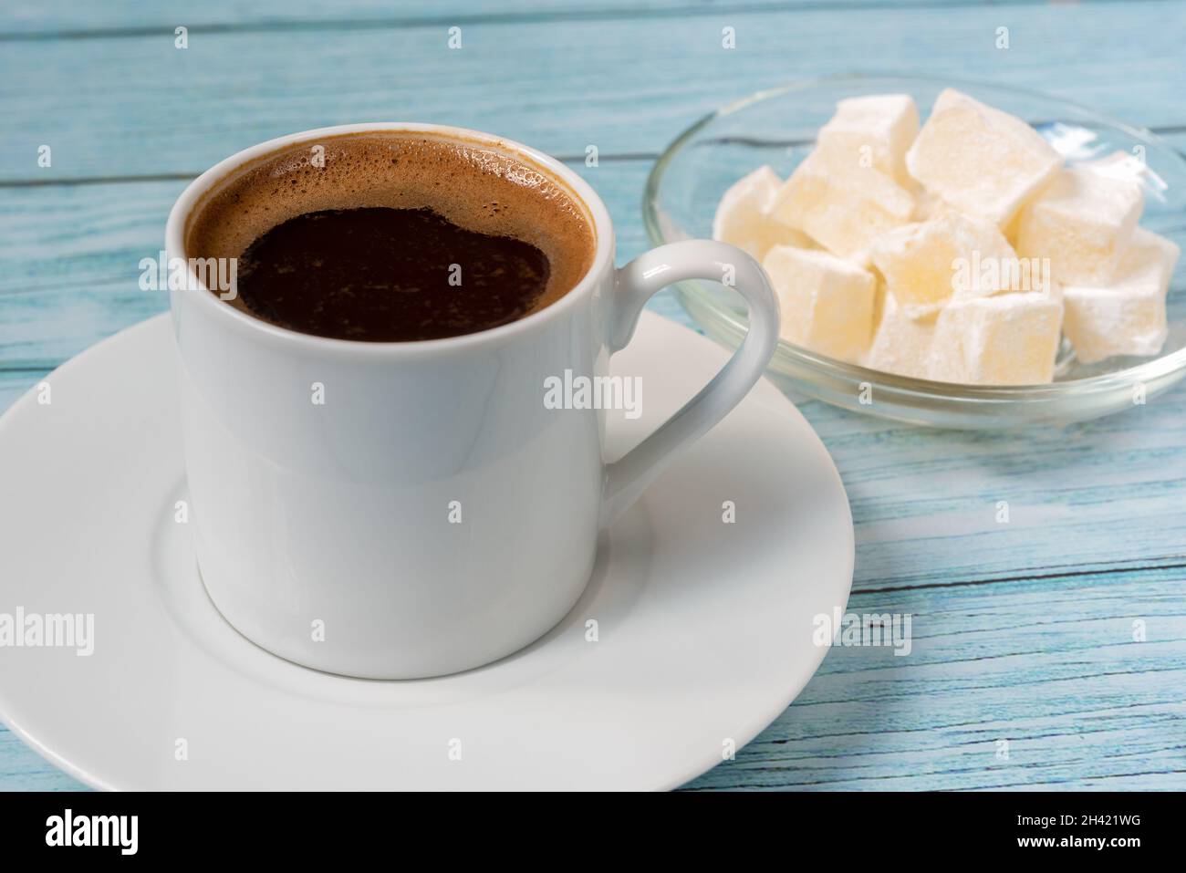 Türkischer Kaffee und eine Schüssel mit türkischem Genuss auf blauem Hintergrund. Stockfoto
