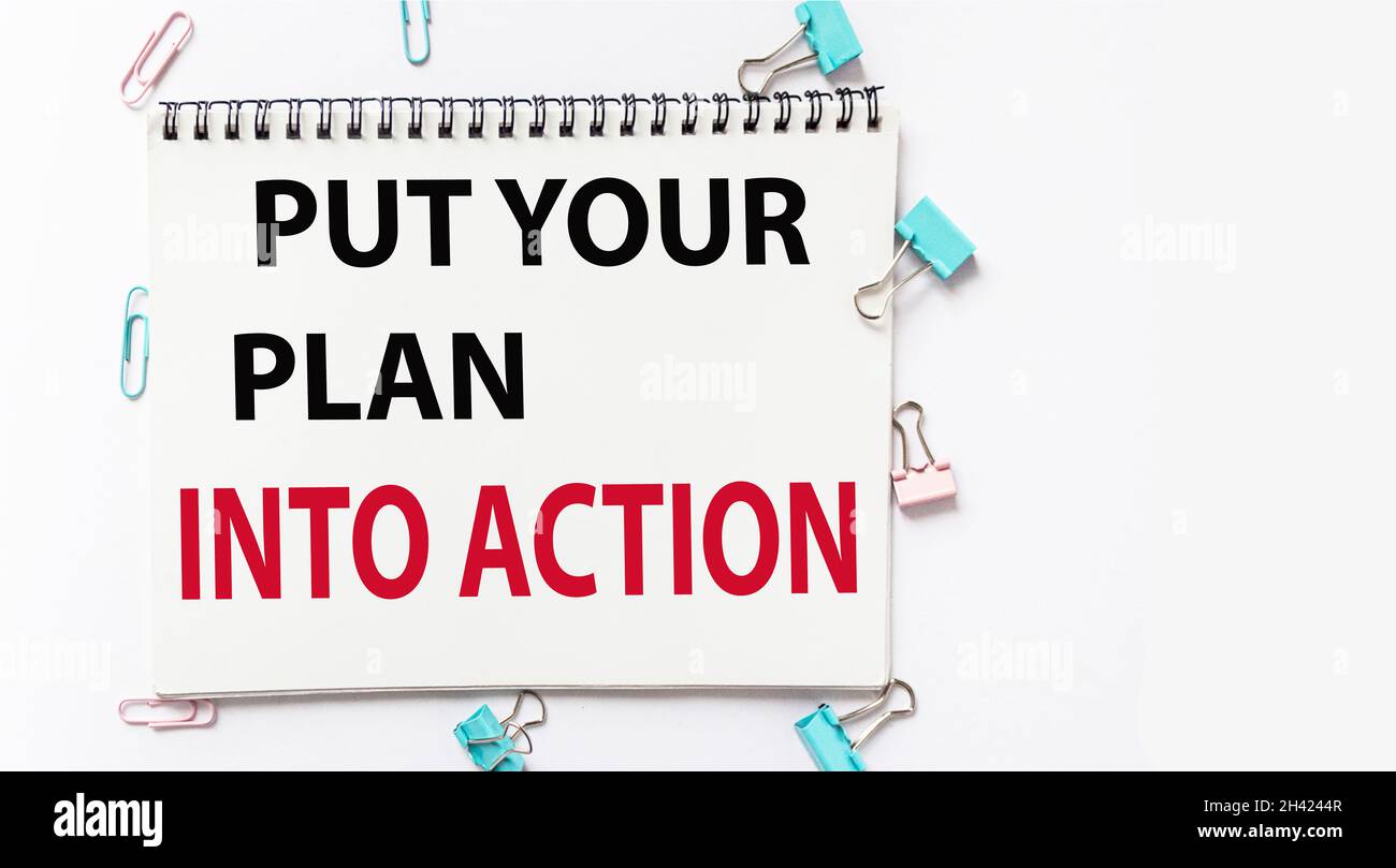 Setzen Sie Ihren Plan in die Tat um, geschrieben auf einem Notizbuch Stockfoto