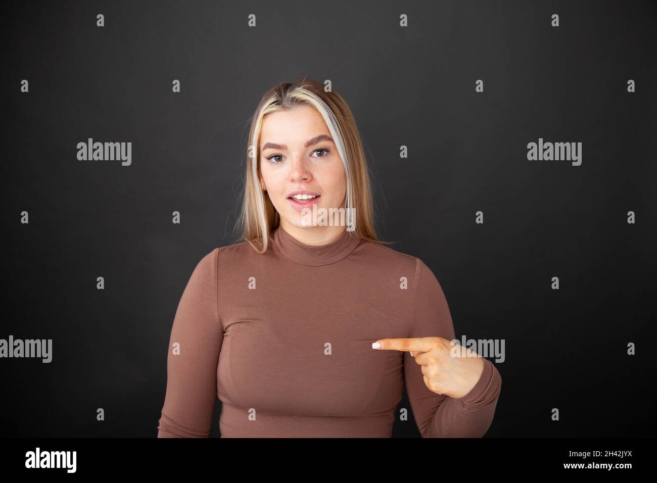 Eine hübsche Teenager-Frau, die auf sich zeigt Stockfoto