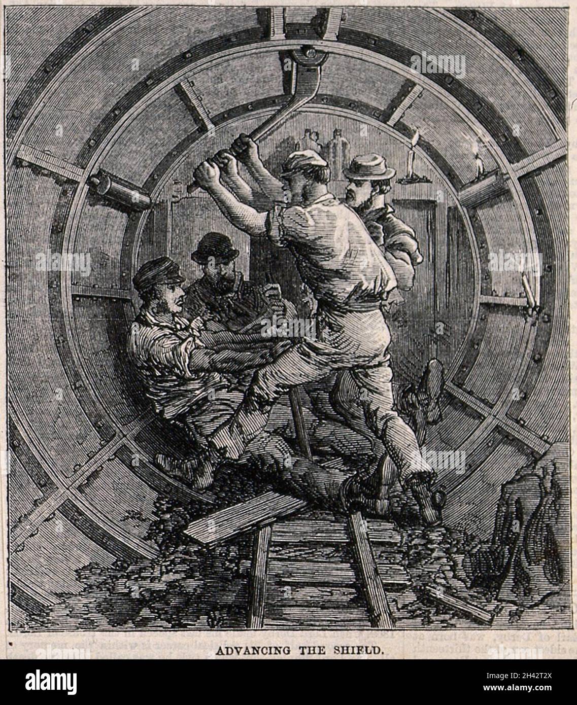 Arbeiter, die die Metallgehäuse für einen unterirdischen Tunnel einbauten. Holzstich, 1868. Stockfoto