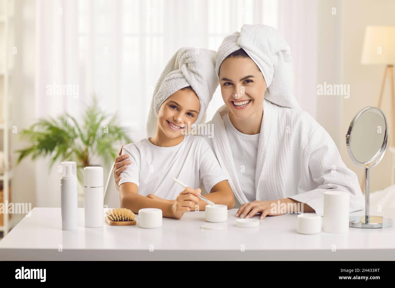 Die junge Mutter und ihre Tochter im Teenageralter organisieren einen Schönheitssalon und verbringen gemeinsam einen Kurtag. Stockfoto