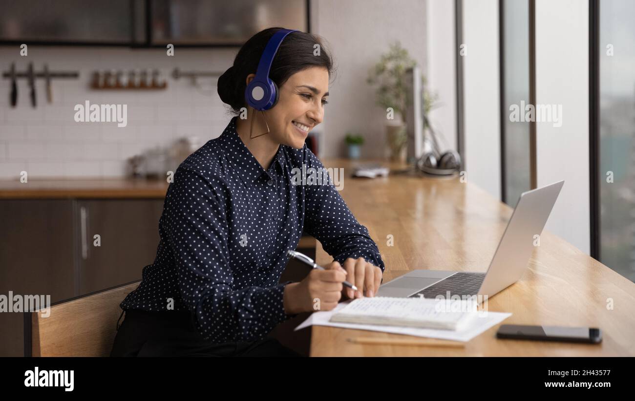 Glückliche tausendjährige indische Frau E-Learning zu Hause. Stockfoto