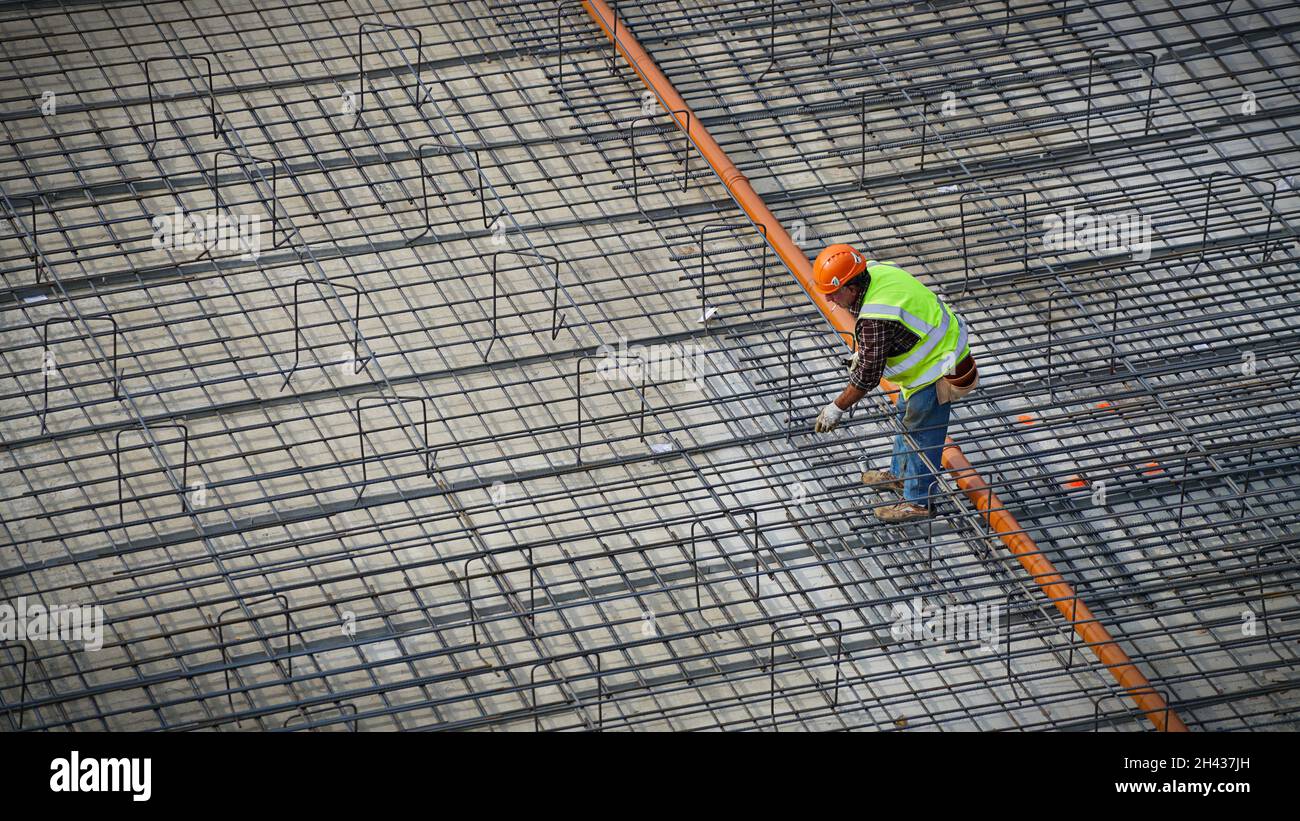 Bauarbeiter, die Stahlarmierungsstäbe auf dem Gelände eines neuen Gebäudes montieren. Mailand, Italien - Oktober 2021 Stockfoto