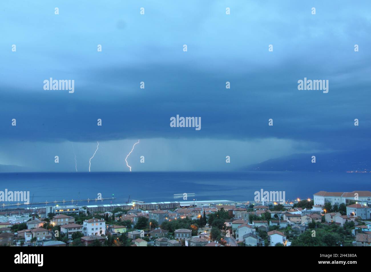 Sturm nähert sich der Meeresstadt Rijeka in Kroatien vom Golf von Rijeka. Blitzsturm Über Der Stadt. Blitzschlag Über Den Dunkelblauen Himmel In Der Stadt Der Nacht Stockfoto