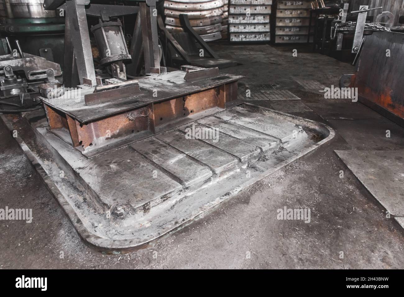 Fräsmaschinenbett, Ausrüstung aus dem Graben für die Kühlmittelentwässerung, schmutzige Produktion in der Werkstatt des Industriewerks. Stockfoto