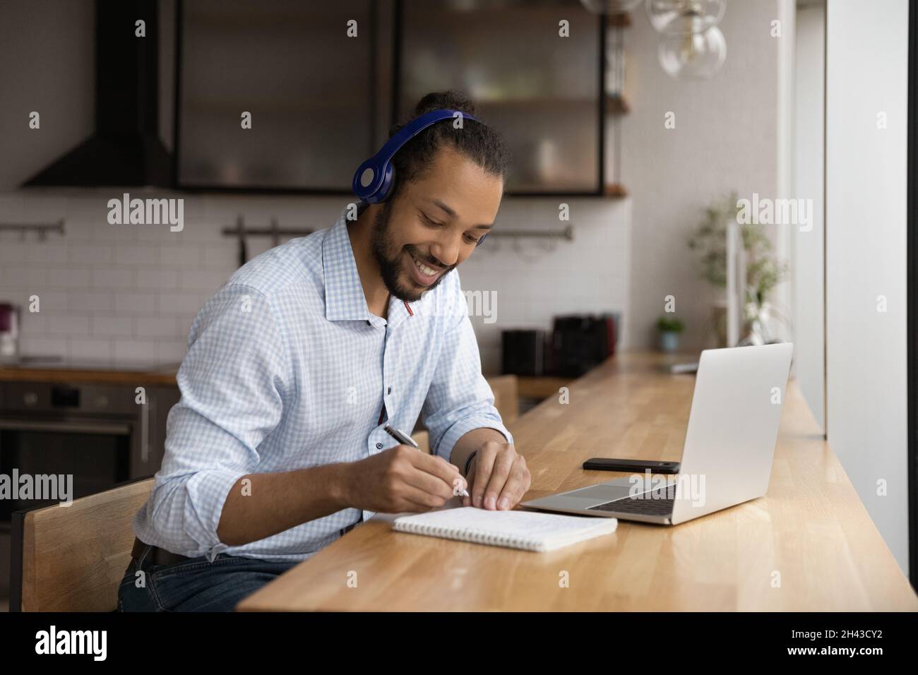 Glücklicher junger afroamerikanischer Mann e-Learning zu Hause. Stockfoto