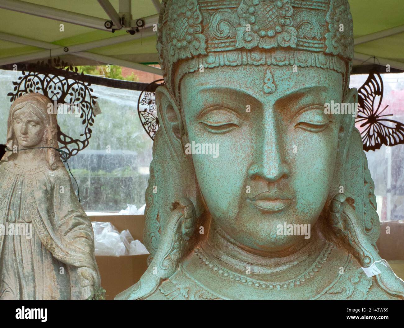 Gartenschmuck mit einem religiösen Thema, der an einem Stall auf einem Straßenmarkt verkauft wird. Stockfoto