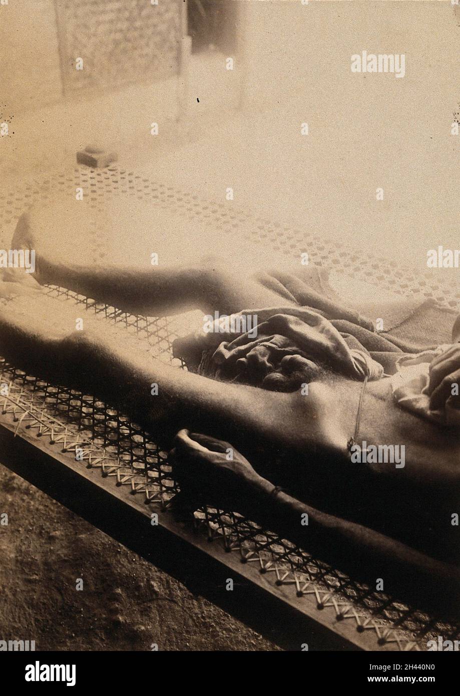 Ein Inder, ein Opfer der Pest in Bombay, der auf einem Rattanbett im Sonnenschein liegt. Foto, ca. 1897. Stockfoto