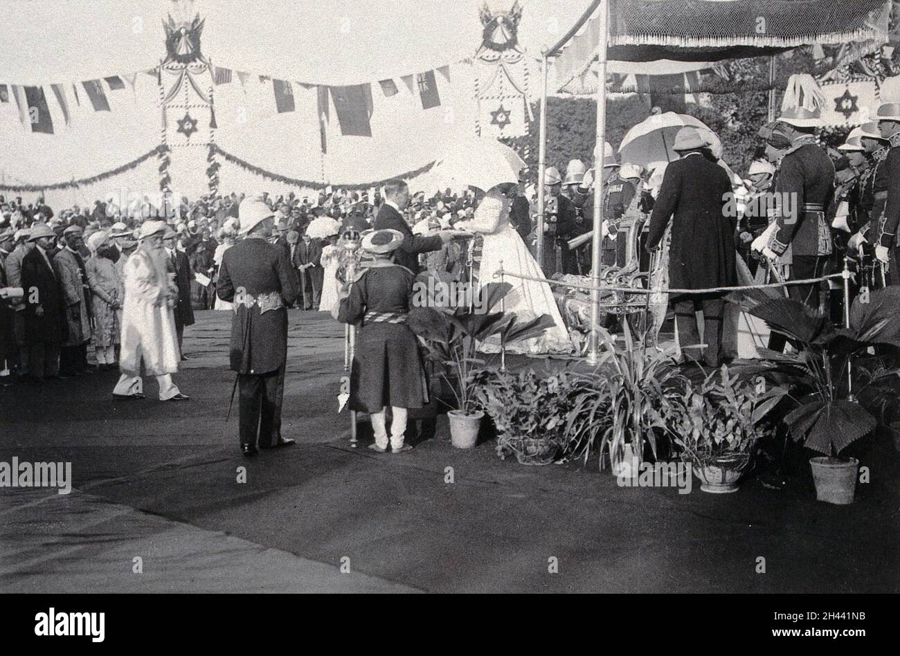 Prinsep Ghat, Kalkutta, Indien: Die Prinzessin von Wales (später Königin Mary) hält einen Sonnenschirm und nimmt ein Juwel vom Vorsitzenden der Calcutta Municipal Corporation entgegen, vor einer Menge Zuschauer. Foto, 1906. Stockfoto