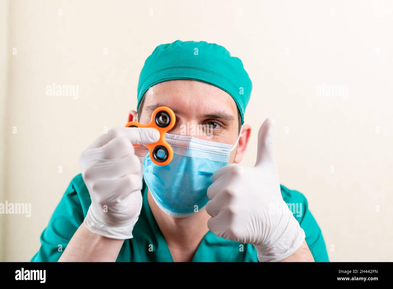 Ein Arzt in einer Maske und Handschuhen, mit einem Spinner in den Händen. Stockfoto