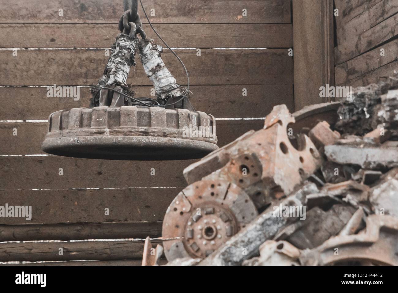 Magnetschrottkran recycelt und entlädt Müll und altes Metall auf einer Deponie. Stockfoto