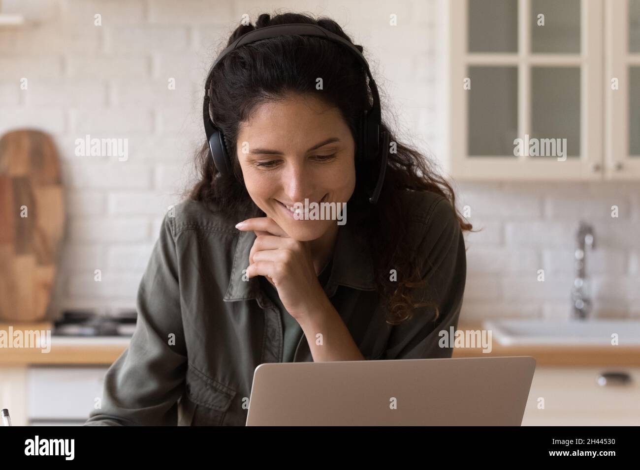 Frau, die zu Hause ein Notebook benutzt, sieht sich Webinar-E-Learning an Stockfoto