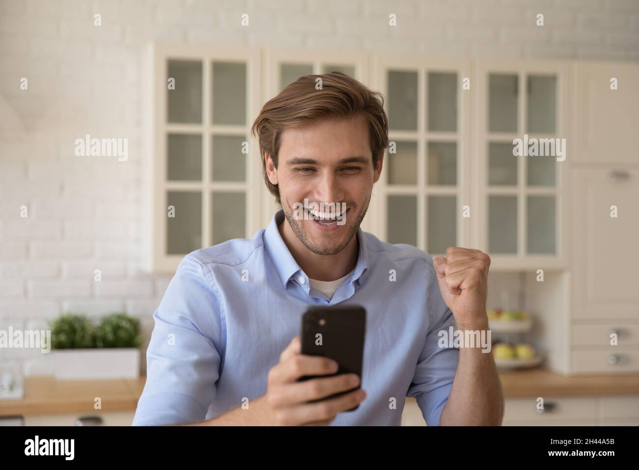 Mann hält Handy Empfangen sie sms mit guten Nachrichten fühlt sich überglücklich Stockfoto