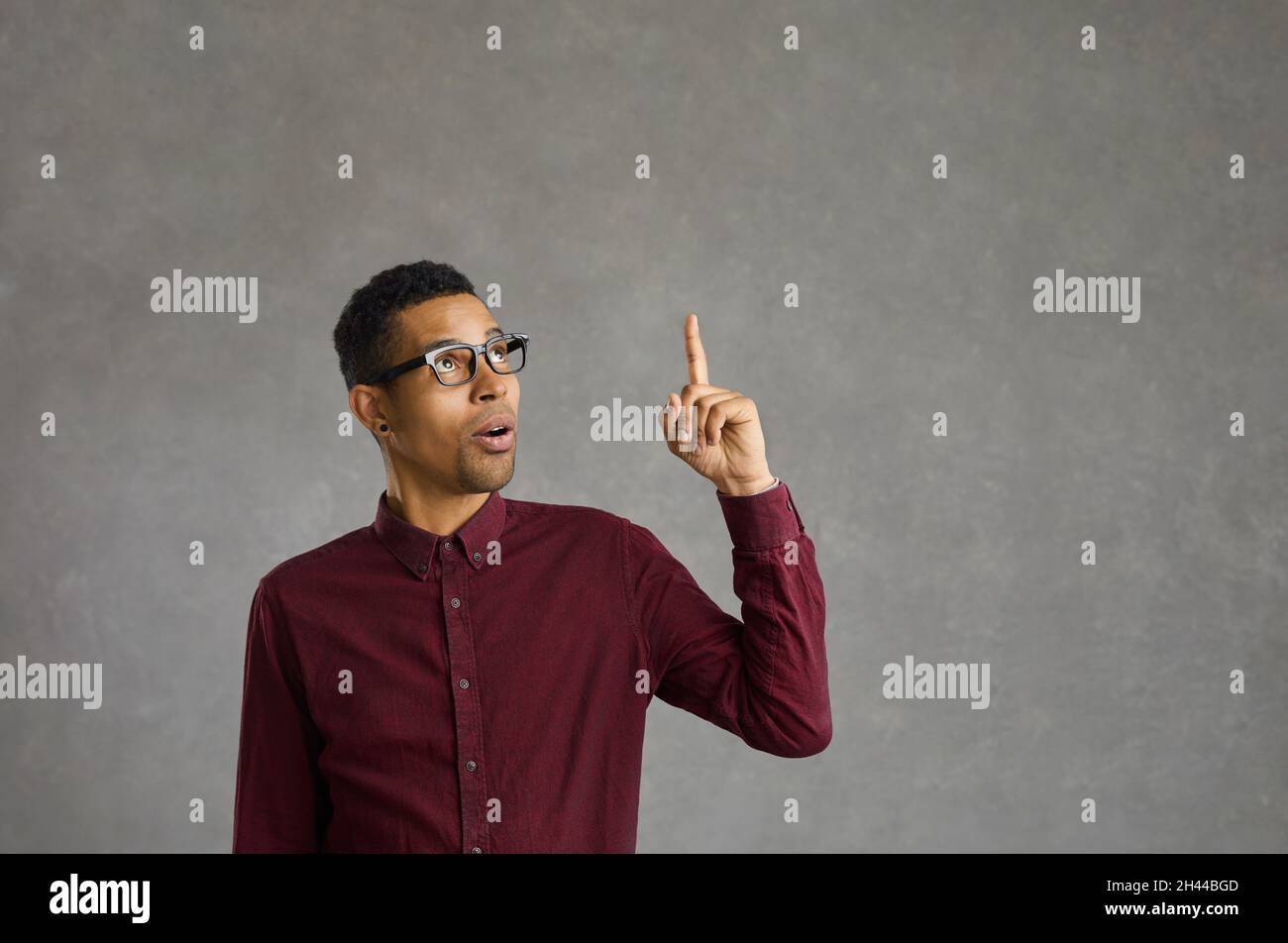 Junger hispanischer Mann, der eine Brille auf einem isolierten schwarzen Hintergrund trägt und eine Handbewegung macht Stockfoto