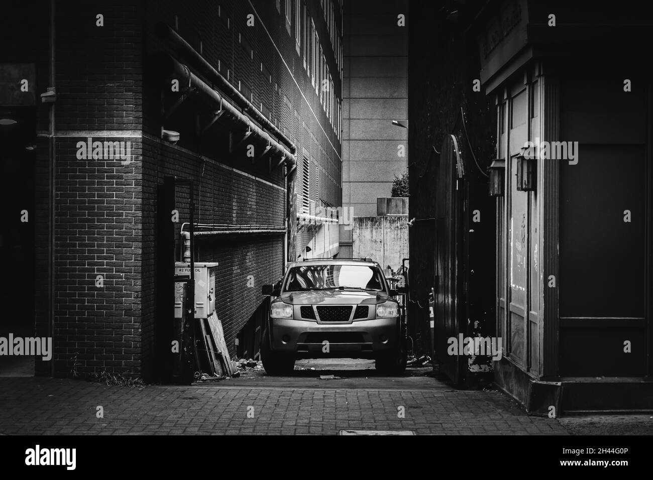 Charlotte, North Carolina, USA - 27. Oktober 2021: Moderner SUV in schwarz-weiß geparkt in einer Stadthalle mit Filmkörnern und dunklen Schatten Stockfoto