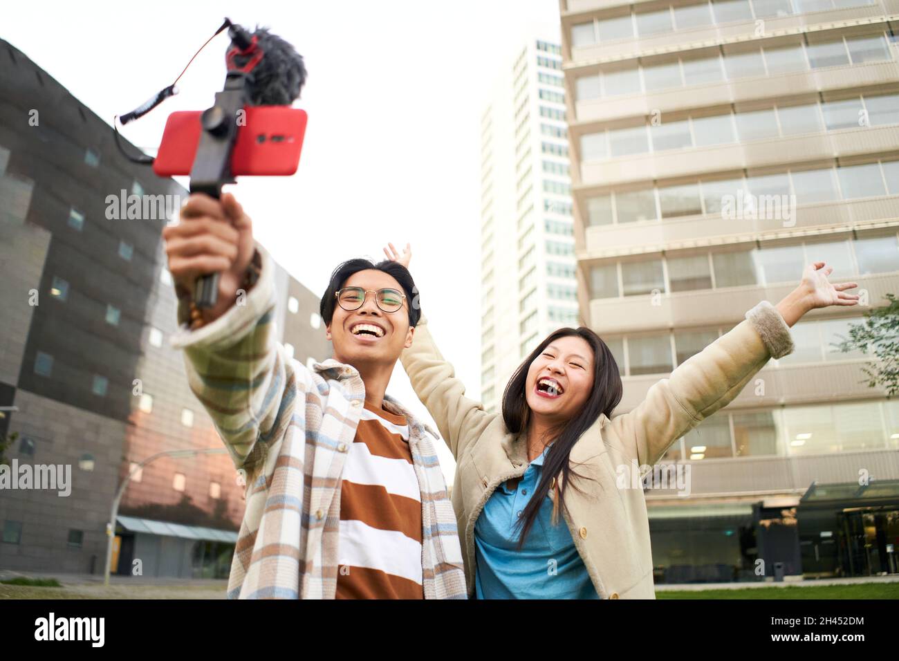 Glückliches asiatisches Paar, das ein Selfie in einer Stadt macht - trendige junge Freunde, die Spaß mit dem Technologie-Trend haben - Konzept der Technologie, Freundschaft und Stockfoto