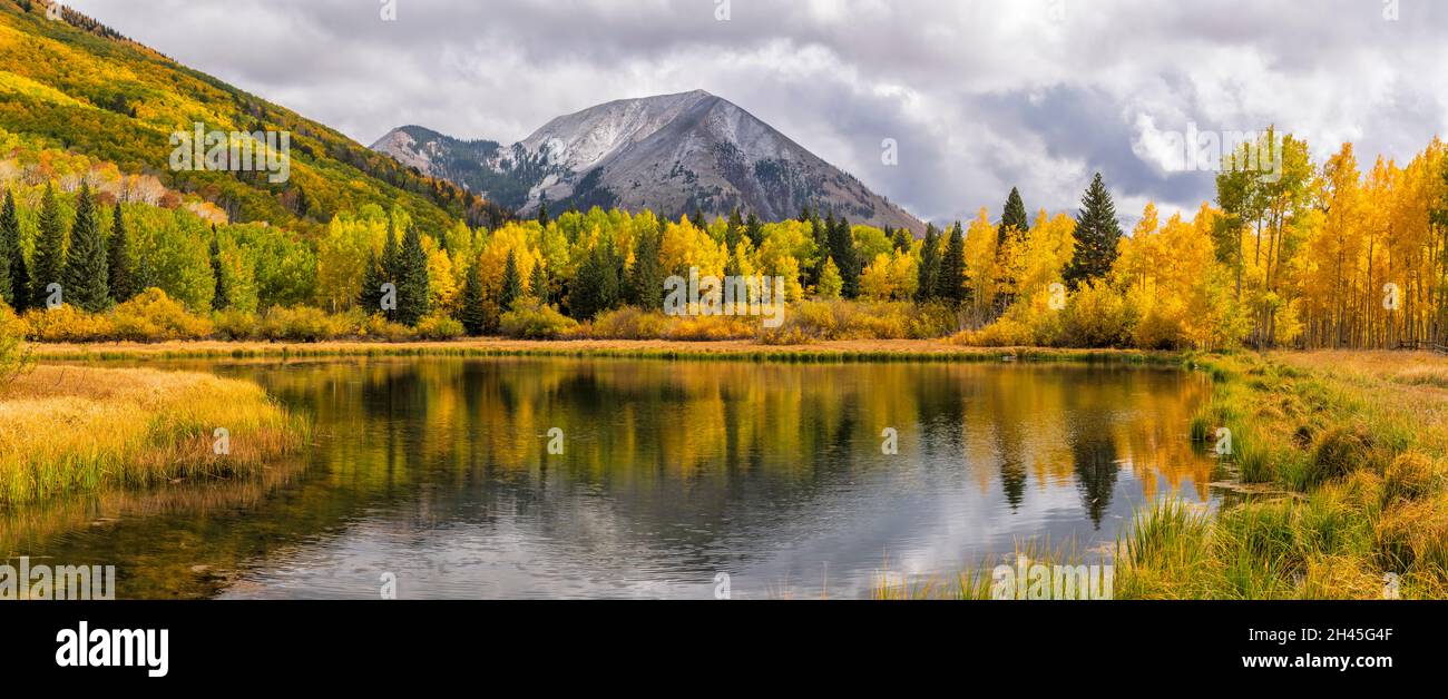 Die sonnenbeschienenen Herbstfarben spiegeln sich im Warner Lake im Manti-La Sal National Forest unterhalb des Haystack Mountain in der Nähe von Moab, Utah, wider. Stockfoto