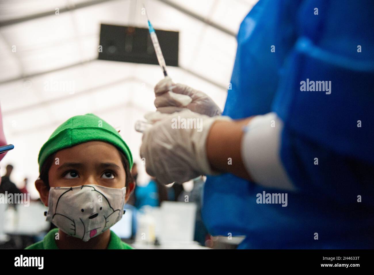 Ein Kind, das an halloween ein Peter Pan Kostüm verwendet, erhält seine erste Dosis des COVID-19-Impfstoffs, da die kolumbianische Regierung am 31. Oktober 2021 in Bogota, Kolumbien, beginnt, Kinder im Alter zwischen 3 und 11 Jahren gegen die Coronavirus-Krankheit (COVID-19) mit dem chinesischen SINOVAC-Impfstoff zu impfen. Stockfoto