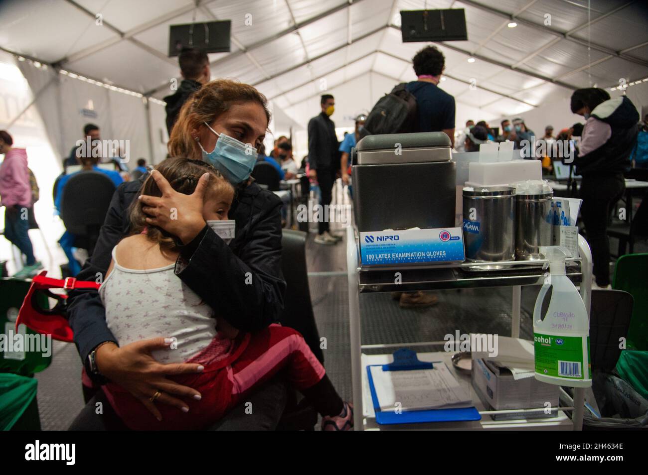 Eine Mutter verdeckt die Augen ihrer Tochter, als sie am 31. Oktober 2021 in Bogota, Kolumbien, die erste Dosis des Impfstoffs SINOVAC COVID-19 erhält, als die kolumbianische Regierung beginnt, Kinder im Alter zwischen 3 und 11 Jahren gegen die Coronavirus-Krankheit (COVID-19) mit dem chinesischen SINOVAC-Impfstoff zu impfen. Stockfoto