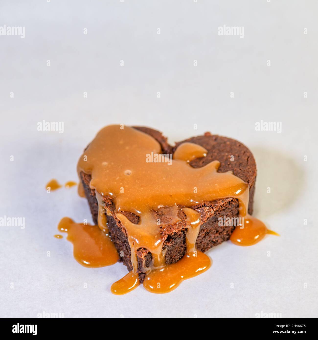 Herzförmiger Schokoladenkuchen mit köstlicher Karamellsauce Stockfoto