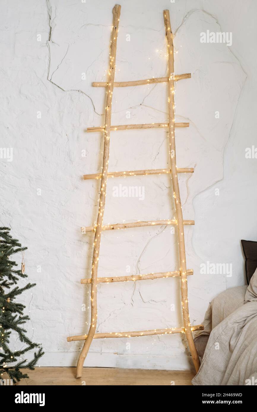 Wohnzimmer Weihnachtsdekor neben dem Bett im Öko-Stil, natürliche Elemente und echte Tannenbaum Holzleiter. Skandinavischer Stil, rustikales Zuhause Copy space Cosy Stockfoto