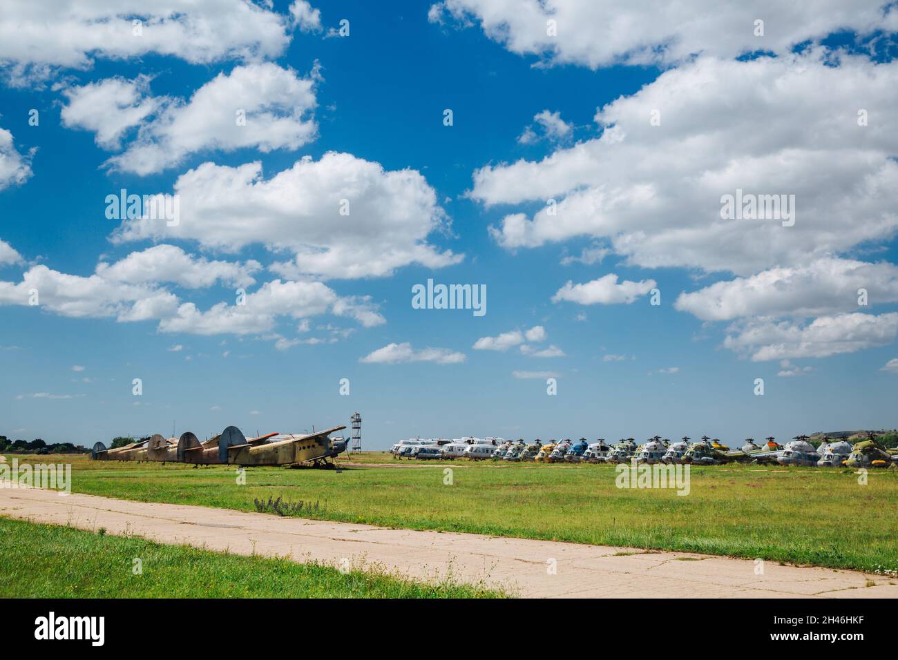 Alte zerstörte verlassene Flugzeuge und Hubschrauber auf dem Feld, Friedhof von alten Hubschraubern und Flugzeugen. Stockfoto