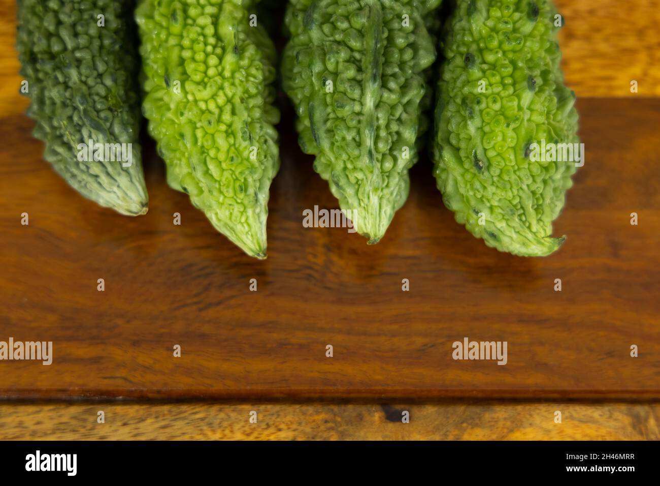 Frisches und grünes bitteres Kürbisgemüse auf einem Holztisch mit Kopierfläche Stockfoto