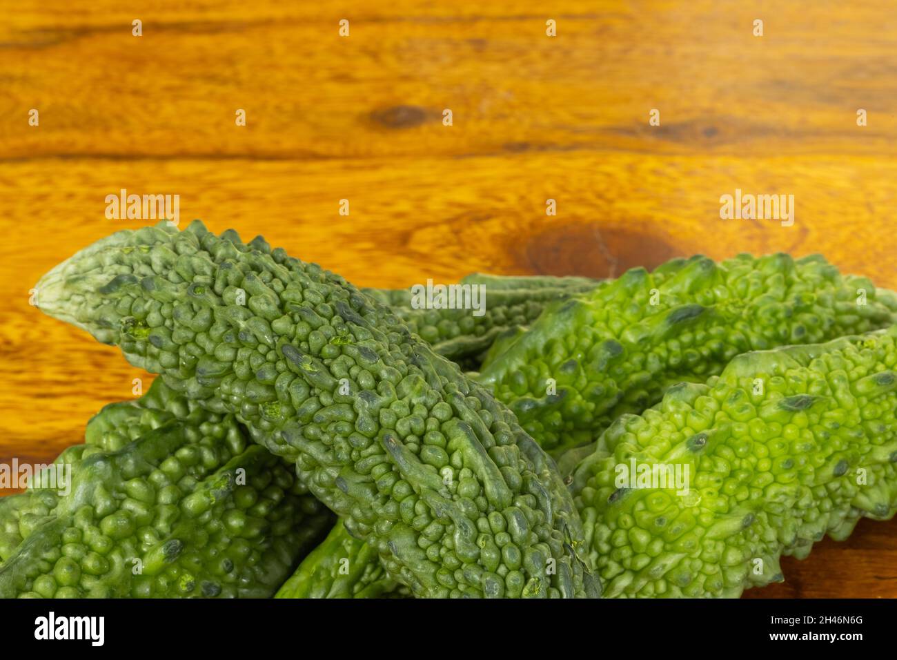 Frisches und grünes bitteres Kürbisgemüse auf einem Holztisch mit Kopierfläche Stockfoto