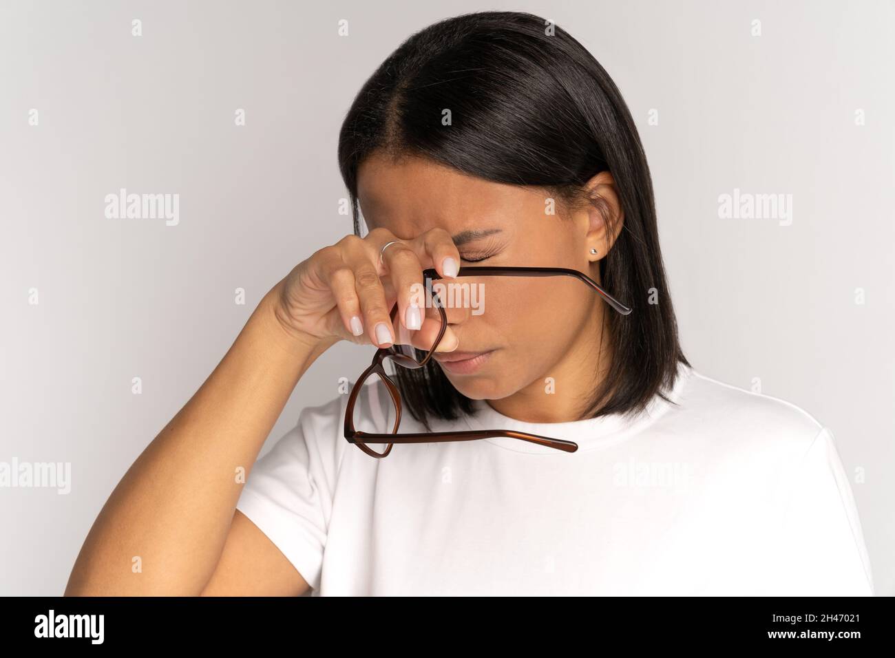 Müde afrikanische Frau, die die Brille auszieht, reibt Nasenrücken leiden unter Belastung und Trockenaugen-Syndrom Stockfoto