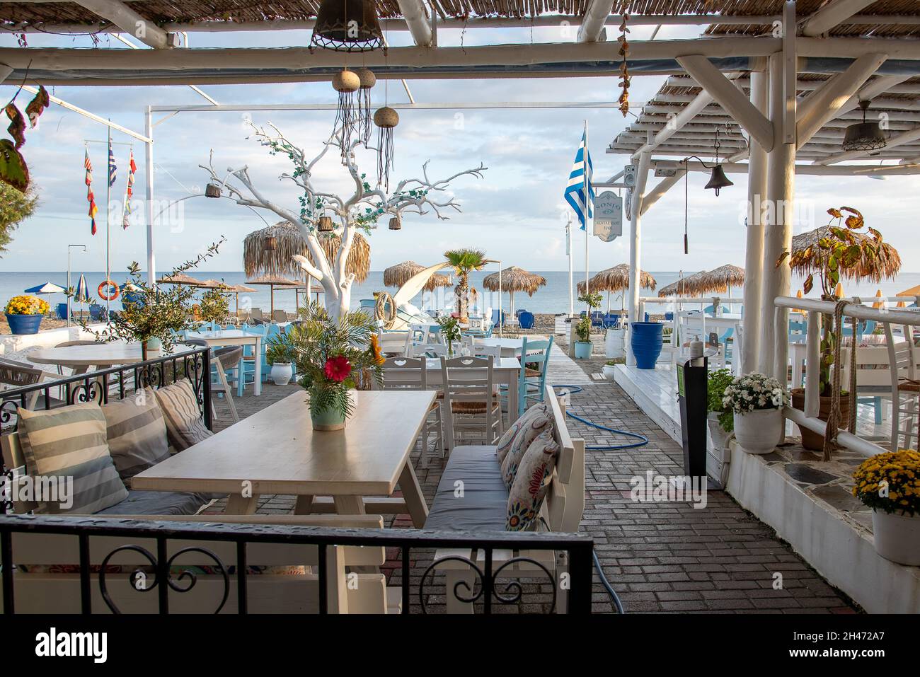 griechisches Restaurant mit blauen und weißen Tischen mit Blick auf den Strand und das blaue Mittelmeer, Platanias, Kreta, Griechenland, Oktober 7, 2021 Stockfoto