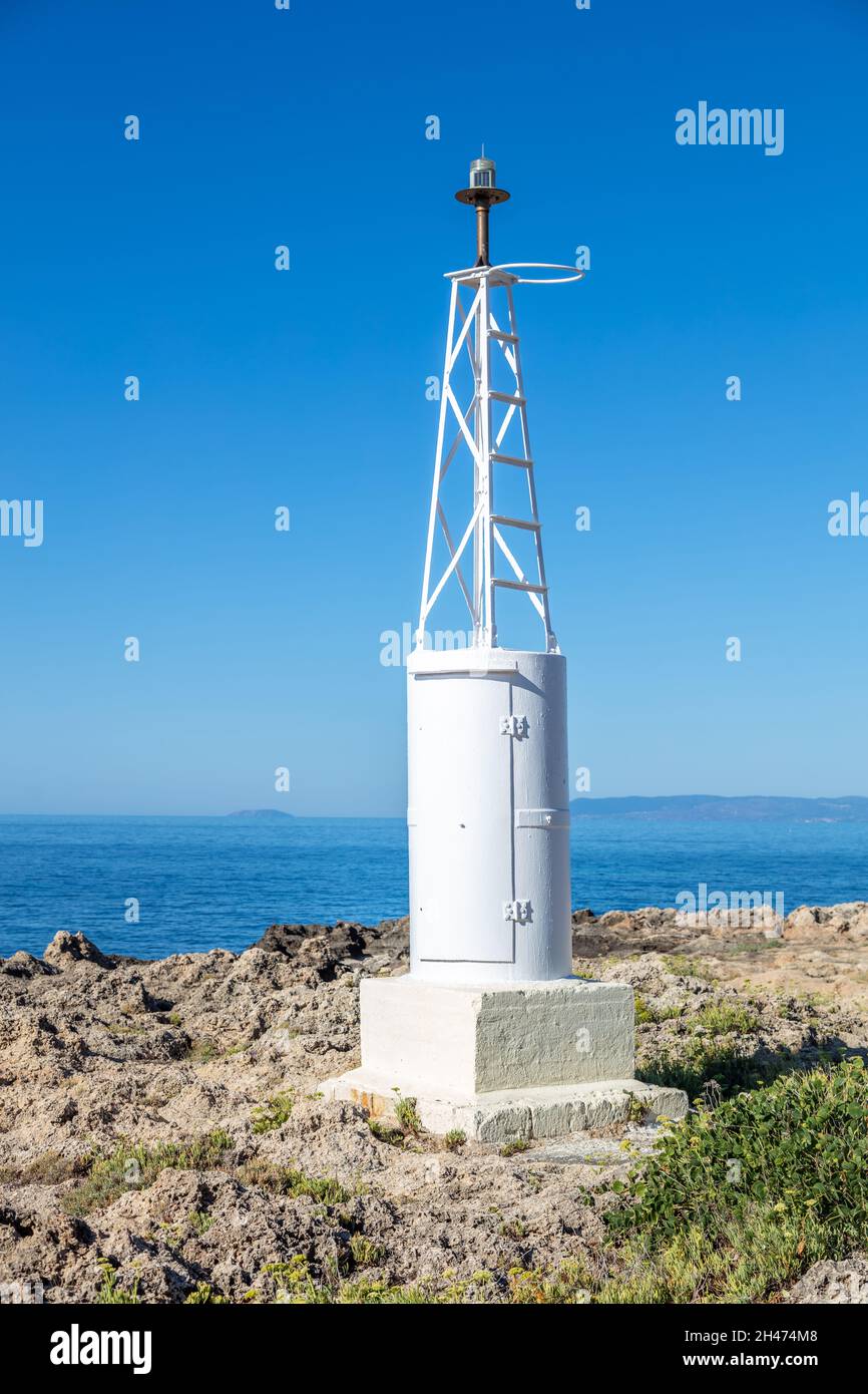 Konzept der sicheren Nachtnavigation. Kleine Leuchtturm Metall weiß Konstruktion am Meer für den Transport zu erleichtern. Rocky Land Beacon klarer blauer Himmel beruhigen AE Stockfoto