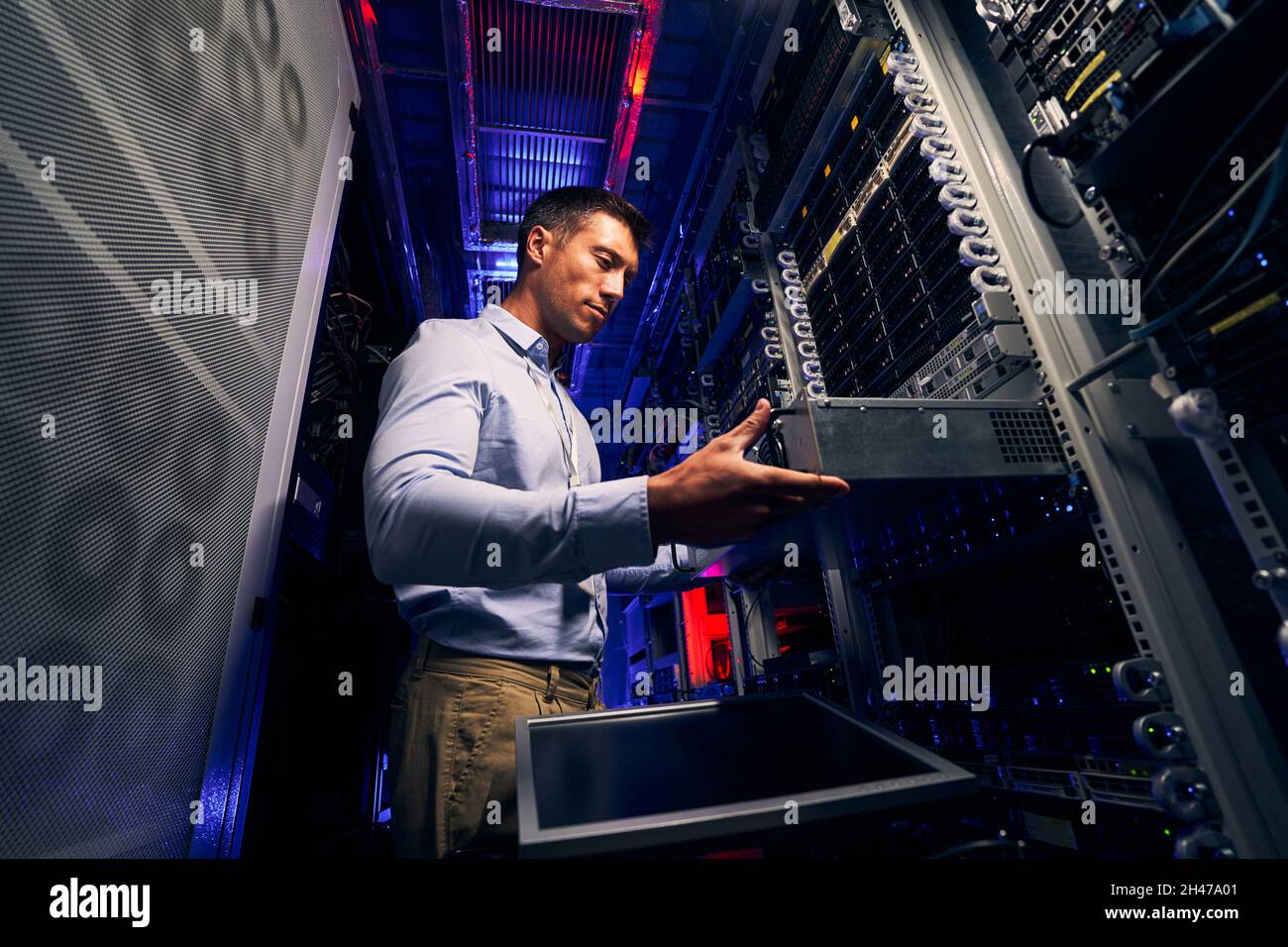 Fachkundiger IT-Techniker im Rechenzentrum, der Hardware-Ausrüstung aufrüstet Stockfoto