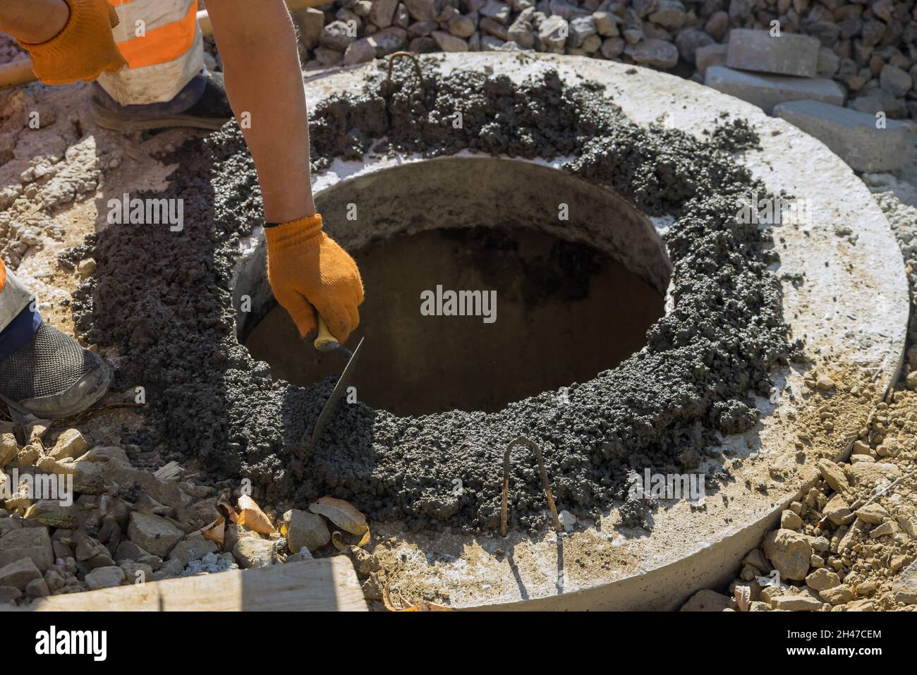 Bauarbeiter Installation von Kanalisation ein Kanalschachtel auf Klärgrube Stockfoto