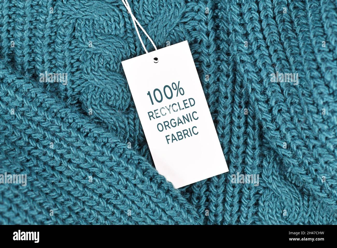 Etikett mit der Aufschrift „100 % recycelter Bio-Stoff“, der an einem umweltfreundlichen Pullover angebracht ist Stockfoto