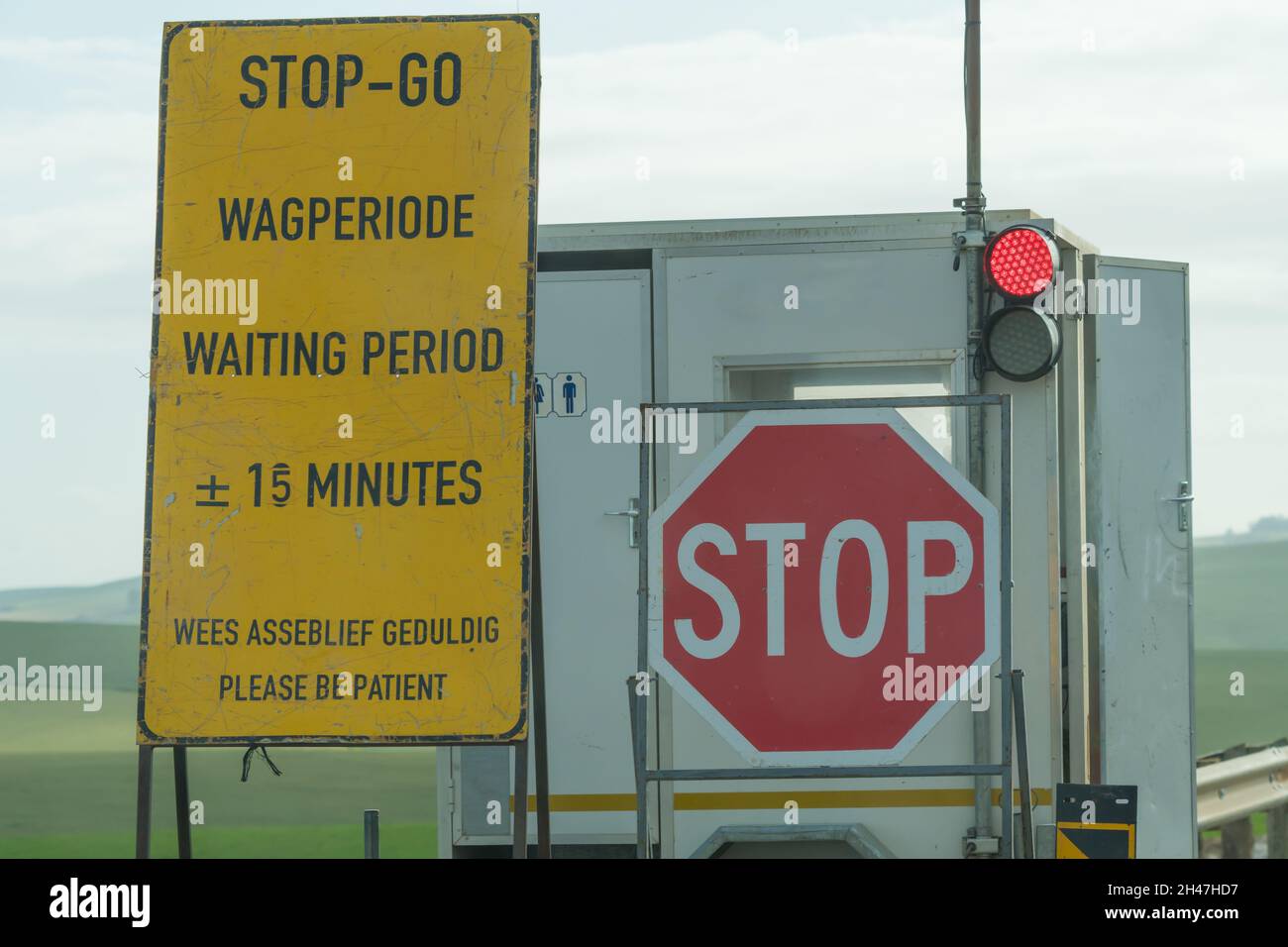 Stop Go Straßenschild und rote Ampel, um den Verkehr auf einer Autobahn zu kontrollieren, die in Südafrika repariert wird Stockfoto