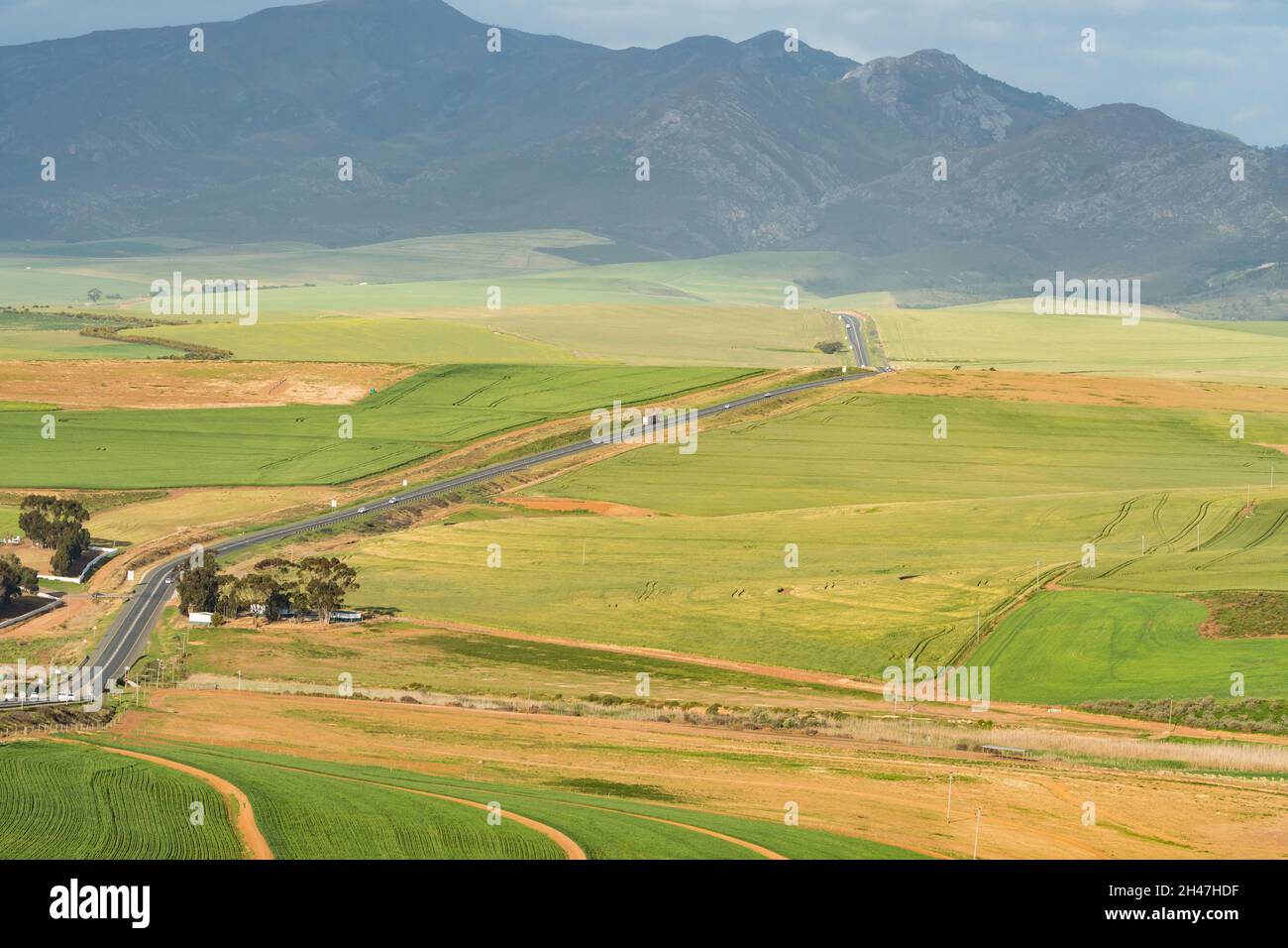 Luftlandschaftslandschaft über Farmen in der Overberg, Western Cape, Südafrika im Frühjahr mit einer Straße oder Autobahn Stockfoto