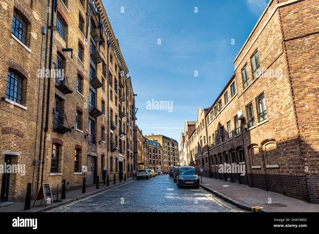 Umgebaute Lagerhäuser und gepflasterte Straße entlang der Wapping Wall, Wapping, London, Großbritannien Stockfoto