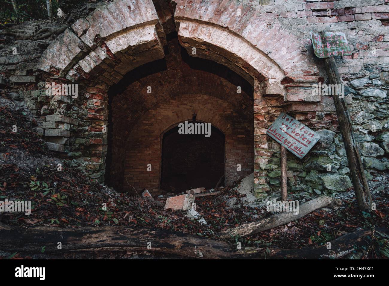 Ein alter verlassene Sandsteinkeller, eine versteckte Höhle im Wald, die in der Vergangenheit zur Lagerung genutzt wurde Stockfoto