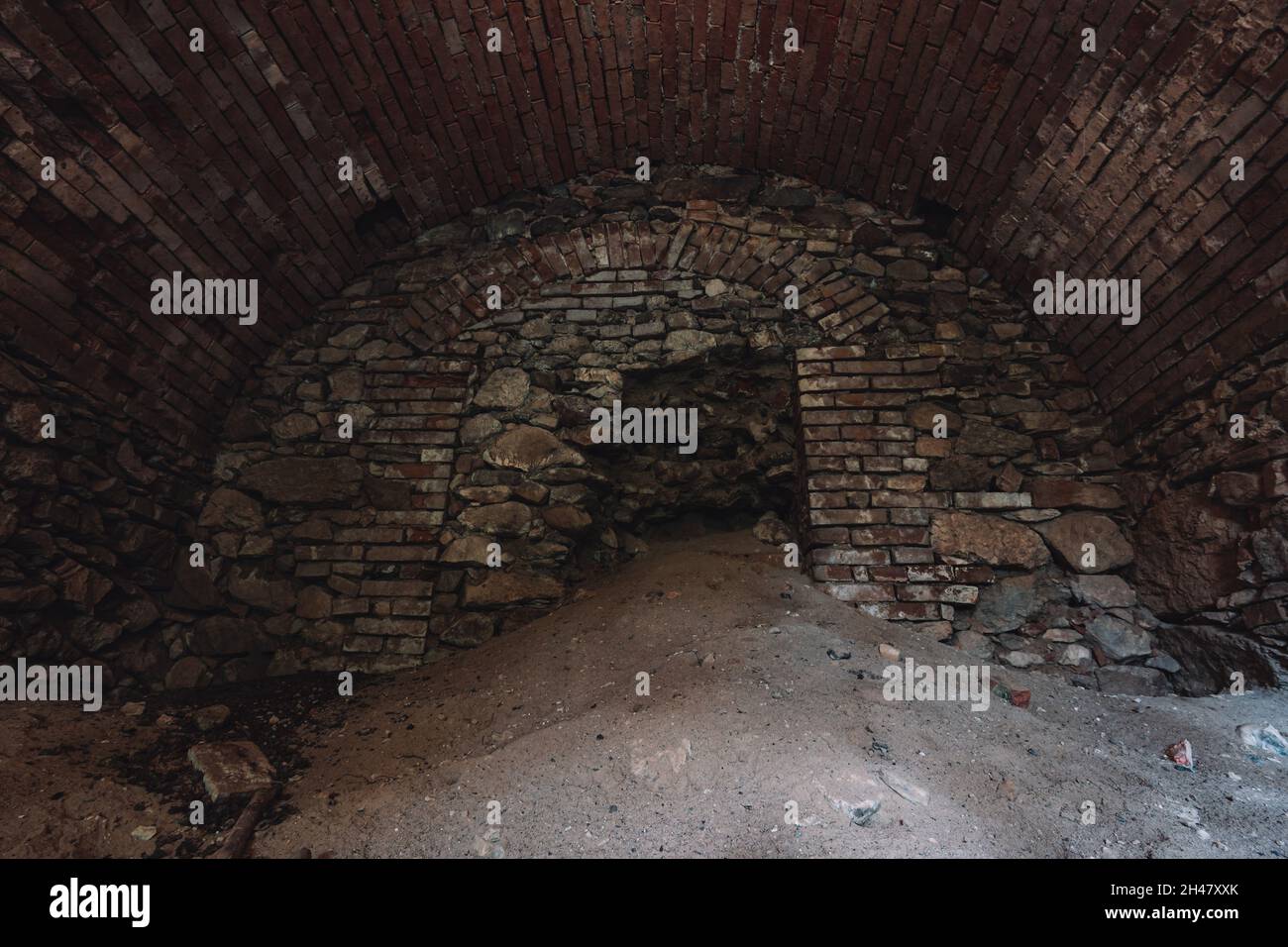 Ein alter verlassene Sandsteinkeller, eine versteckte Höhle im Wald, die in der Vergangenheit zur Lagerung genutzt wurde Stockfoto