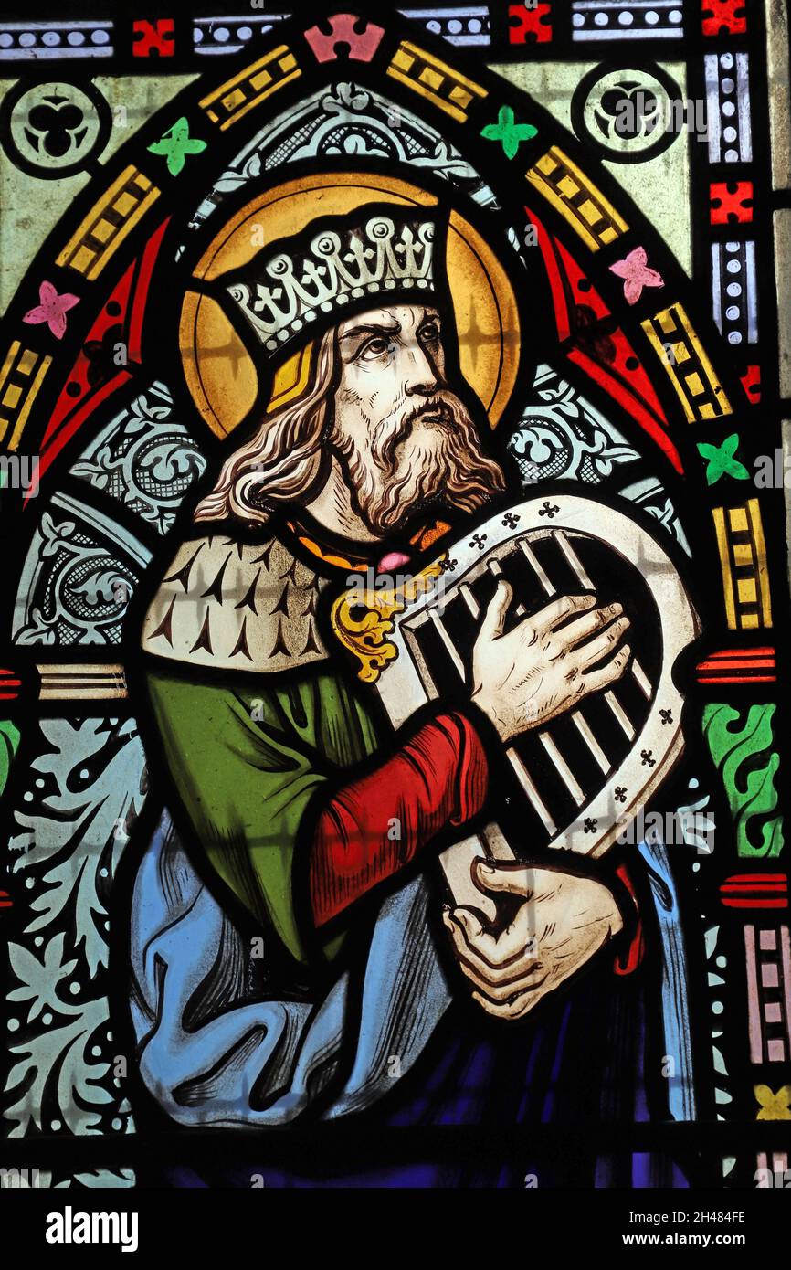 Ein Buntglasfenster von Michael O'Connor, in dem König David in einer Leier spielt, die St. Michael & All Angels Church, Fringford, Oxfordshire Stockfoto