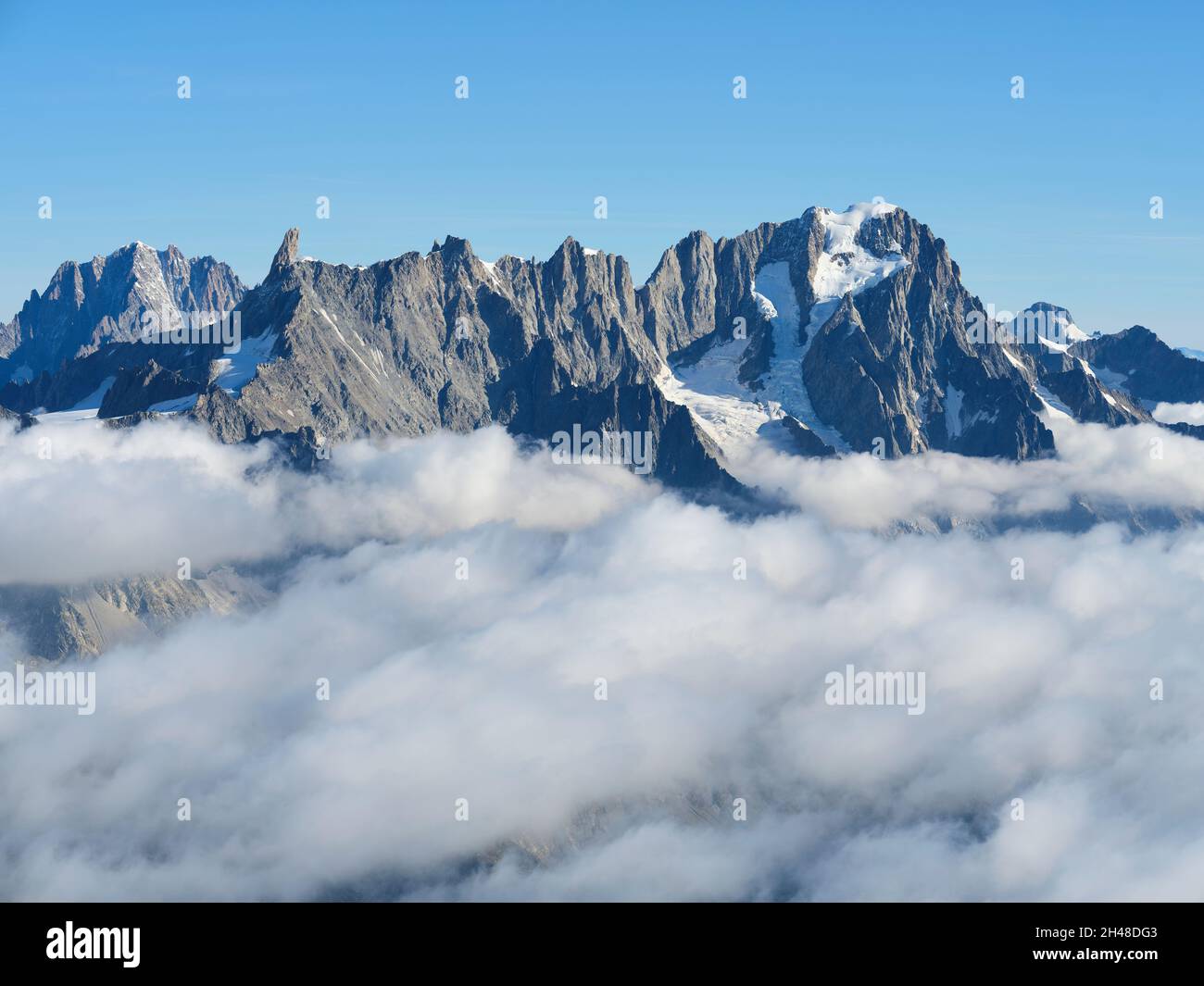 LUFTAUFNAHME. Südöstliche Seite der Aiguille du Géant und der Grandes Jorasses über einem Meer von Wolken. Val Ferret, Courmayeur, Aostatal, Italien. Stockfoto