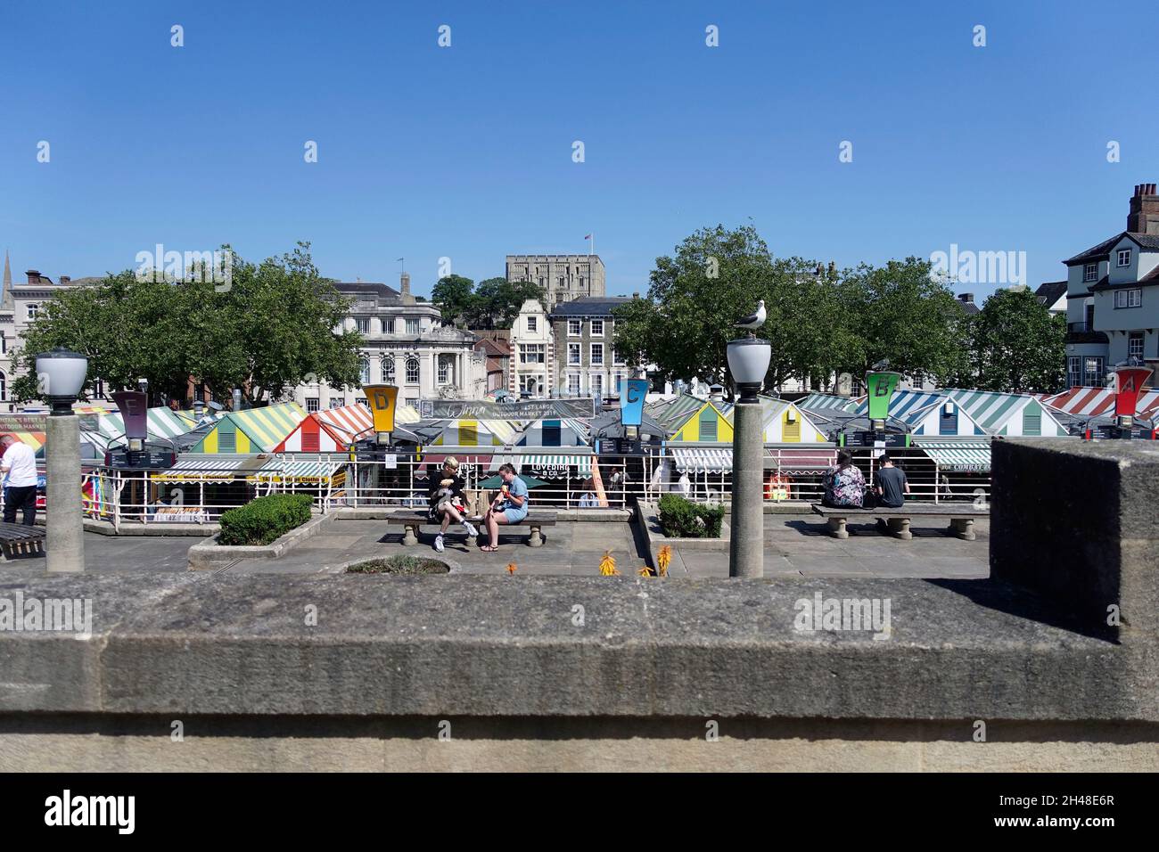 Outdoor-Markt in Norwich, Norfolk, England, Großbritannien – in der Ferne befindet sich Norwich Castle. Ein Banner besagt, dass es ‘Großbritanniens bester großer Outdoor-Markt 2019’ war Stockfoto