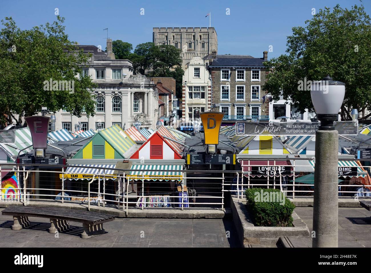 Outdoor-Markt in Norwich, Norfolk, England, Großbritannien – in der Ferne befindet sich Norwich Castle. Ein Banner besagt, dass es ‘Großbritanniens bester großer Outdoor-Markt 2019’ war Stockfoto