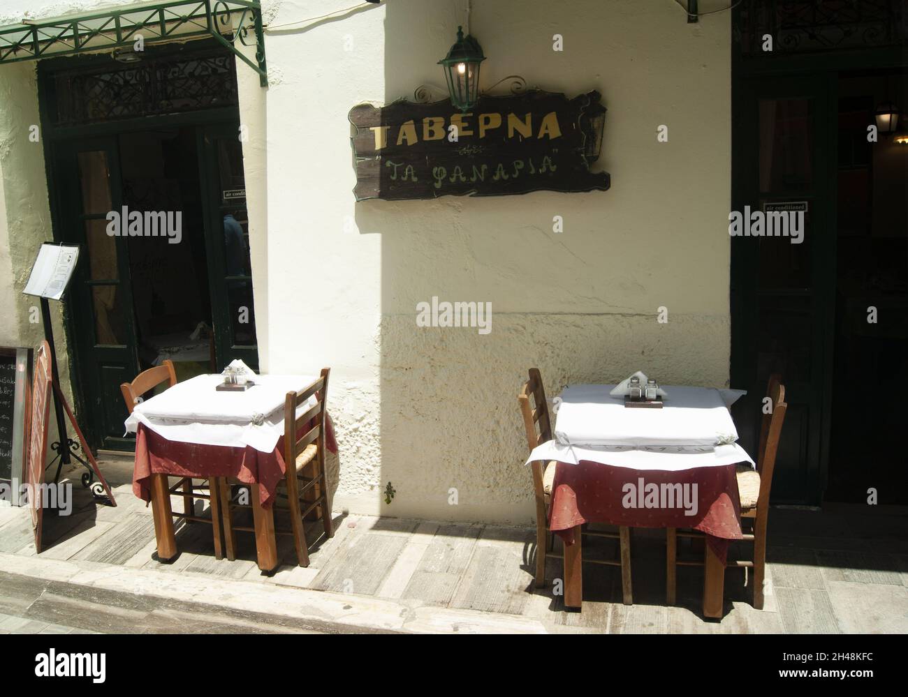 Nafplio Stadt - Griechenland - Mai 25 2018 : traditionelle Taverne in der historischen Altstadt. Tische und Stühle auf der Straße. Landschaftsaufnahme Stockfoto