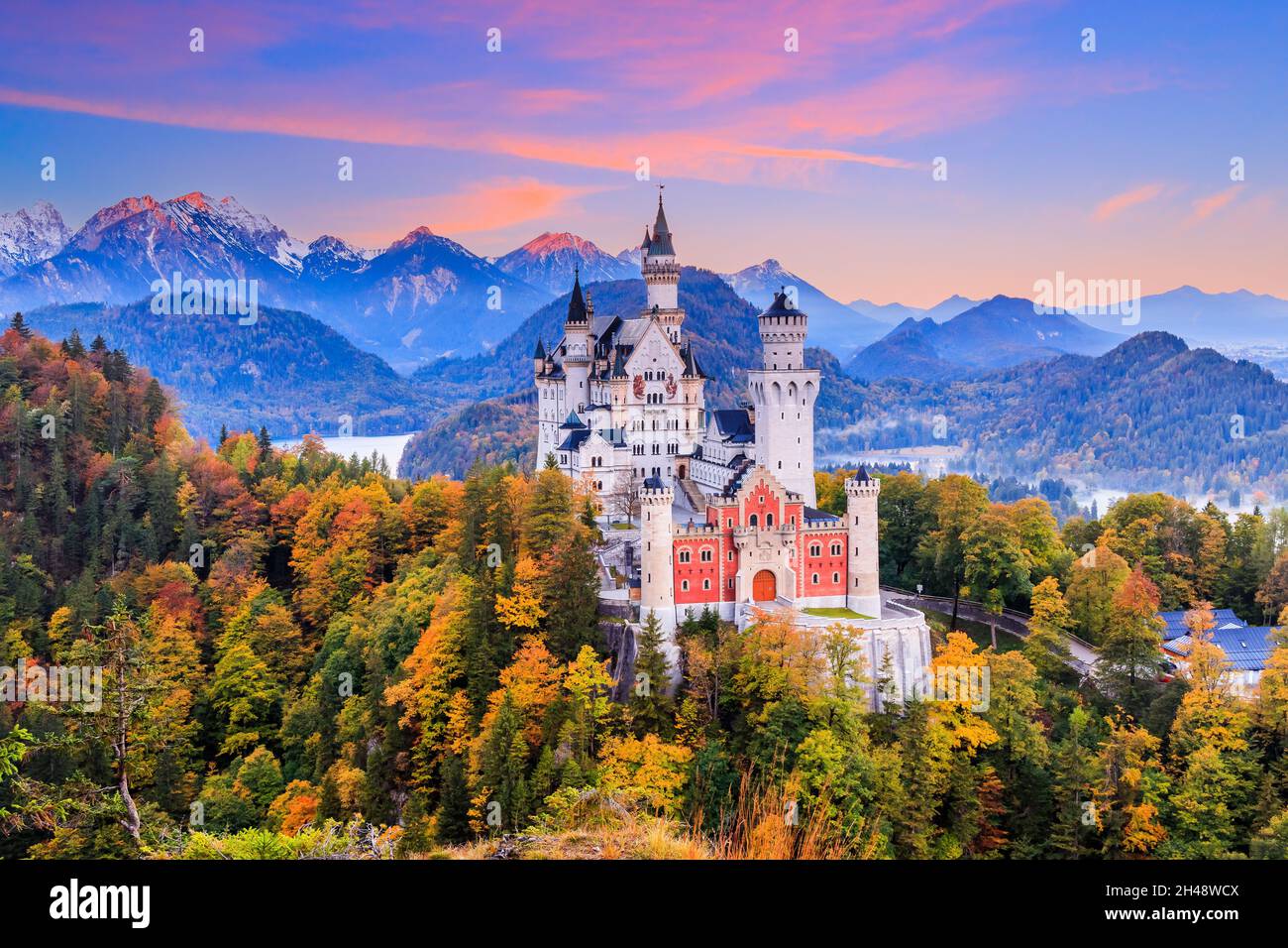 Deutschland, Schloss Neuschwanstein. Blick auf das Schloss und die bayerischen Alpen bei Sonnenaufgang in der Herbstsaison. Stockfoto