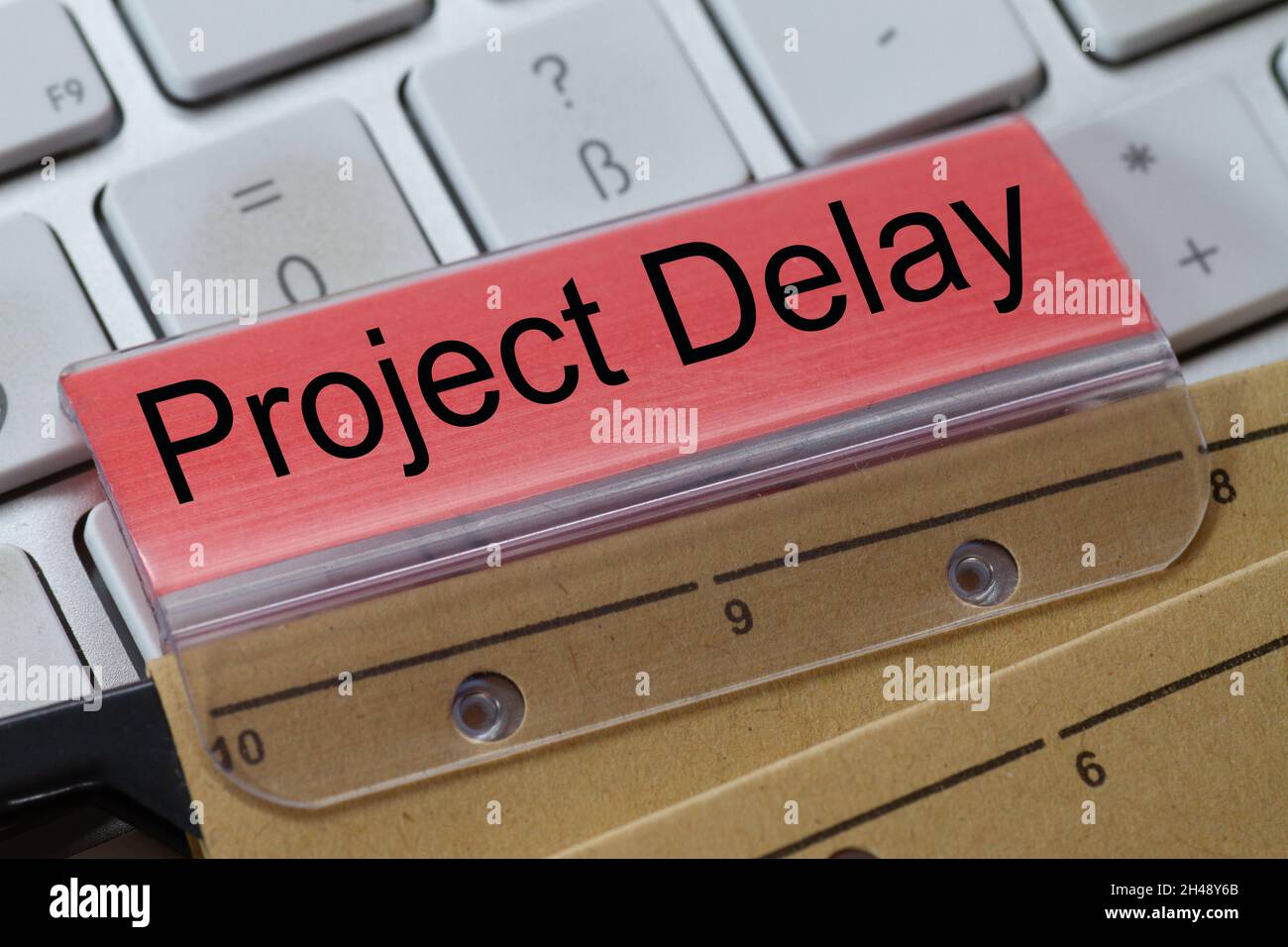 Hängende Datei auf einer Tastatur mit rotem Etikett geschrieben: Projekt Delay Stockfoto